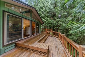 A wooden deck extends outside the exterior of a house. Photo by Im3rd Media on Unsplash